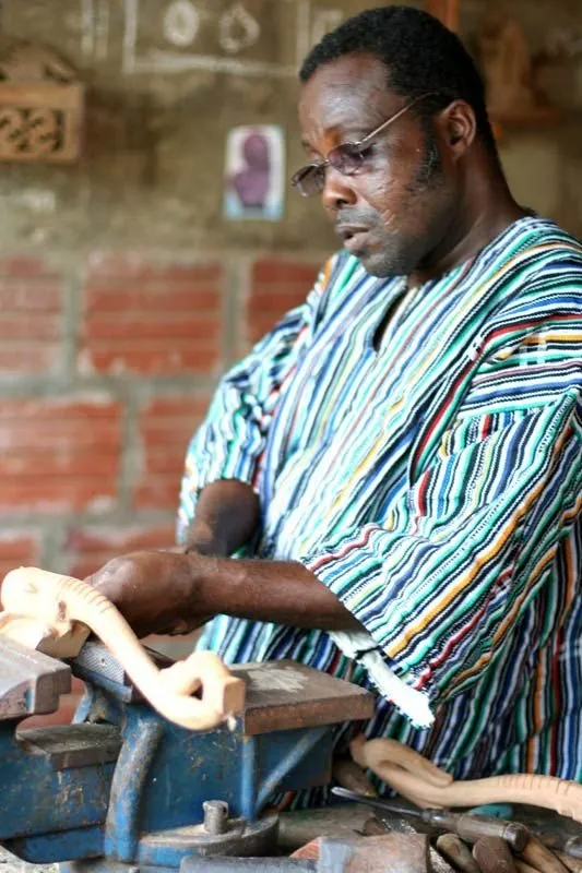 Artisan sculptant une pièce de bois à l’établi